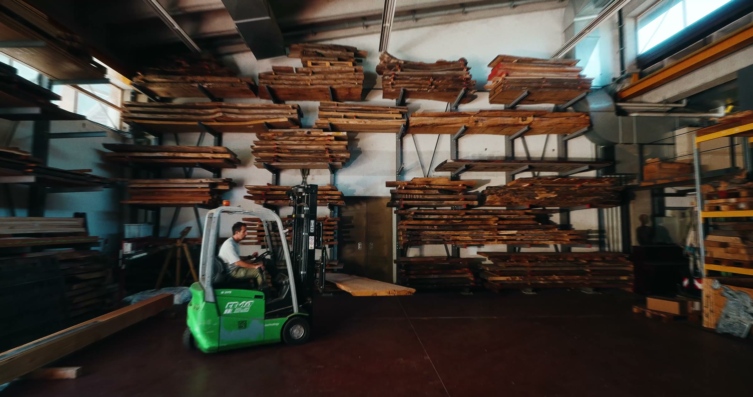 Holzlager von AMK mit Gabelstapler und gelagerten Bohlen